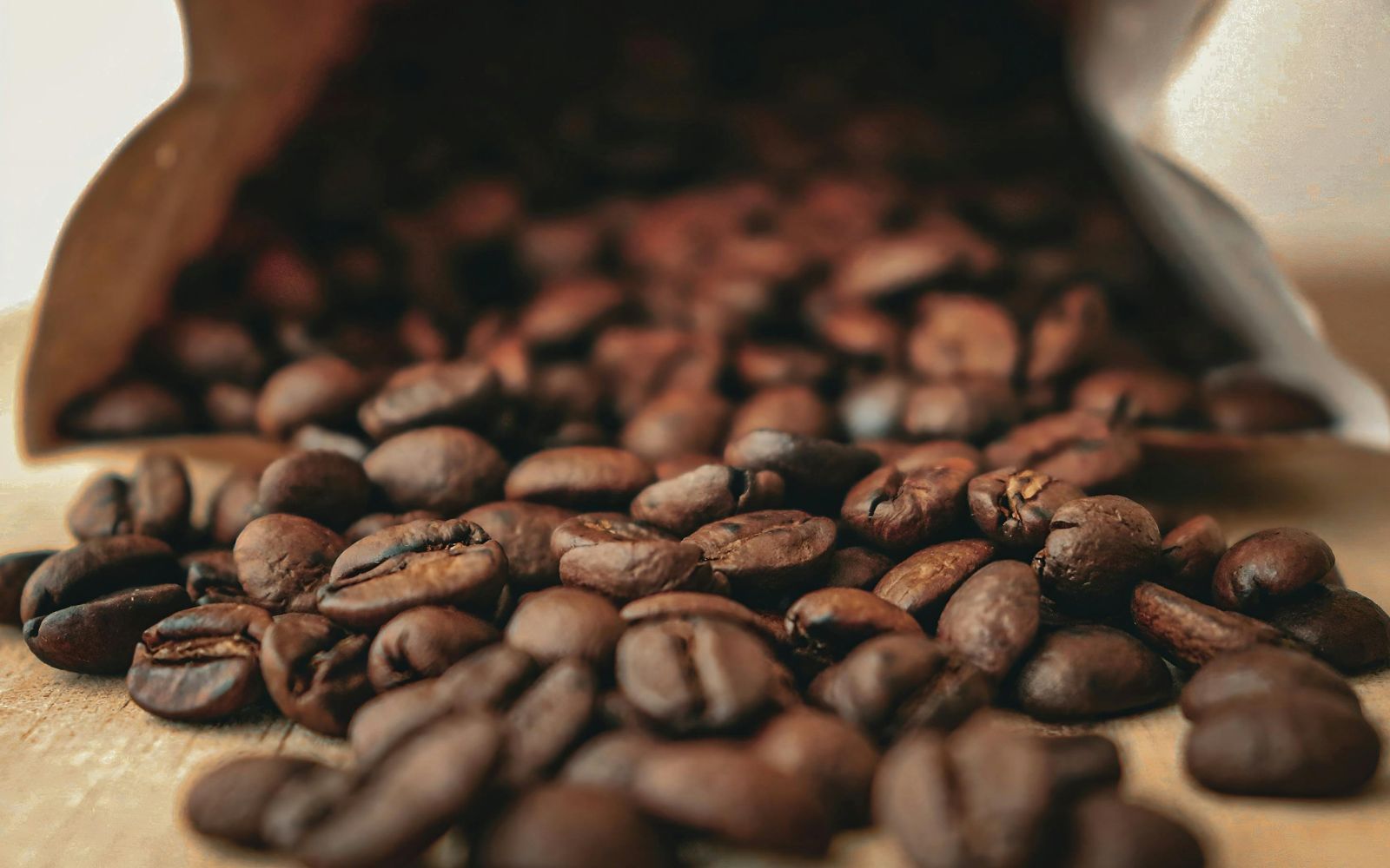 local coffee roasters in St. Pete fresh roasted beans spilling from a burlap bag on a wooden surface
