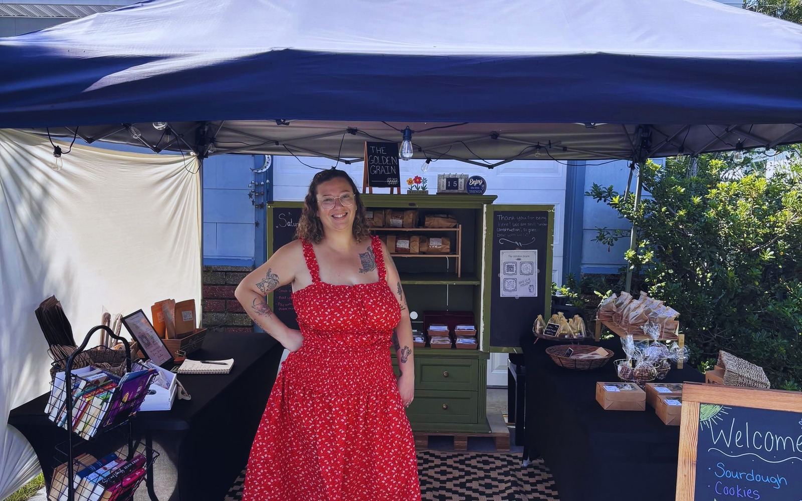 Arica Fernandez smiling at The Golden Grain farm stand, a St. Pete sourdough bakery
